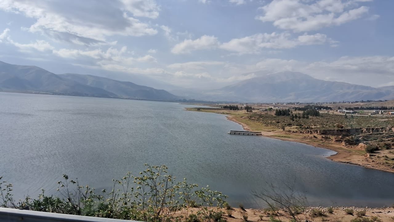 El embalse visto desde la ruta, con el muelle sobre el agua y el pueblo al fondo